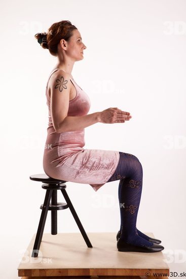 Sitting reference of whole body pink dress purple tights black shoes Nadine