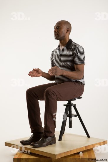 Sitting reference of whole body black white striped shirt brown jeans brown shoes Arturo