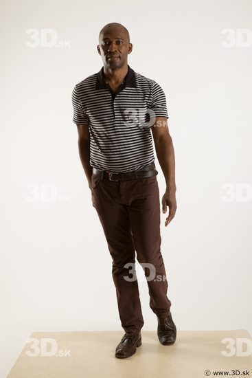 Walking reference of whole body black white striped shirt brown jeans brown shoes Arturo