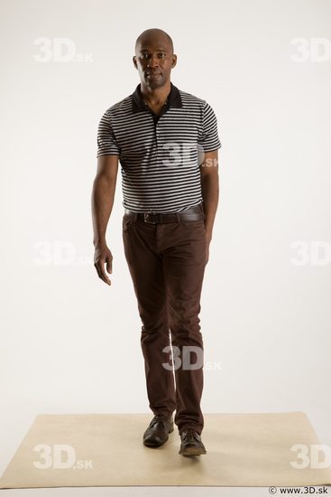 Walking reference of whole body black white striped shirt brown jeans brown shoes Arturo